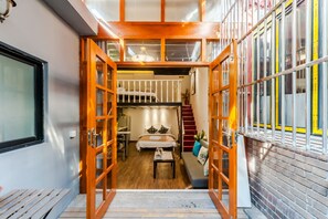 A compact, multi-level room with a bed, a desk, and a staircase. - Qiyu Homestay - West Nanjing Road Branch (Shanghai)