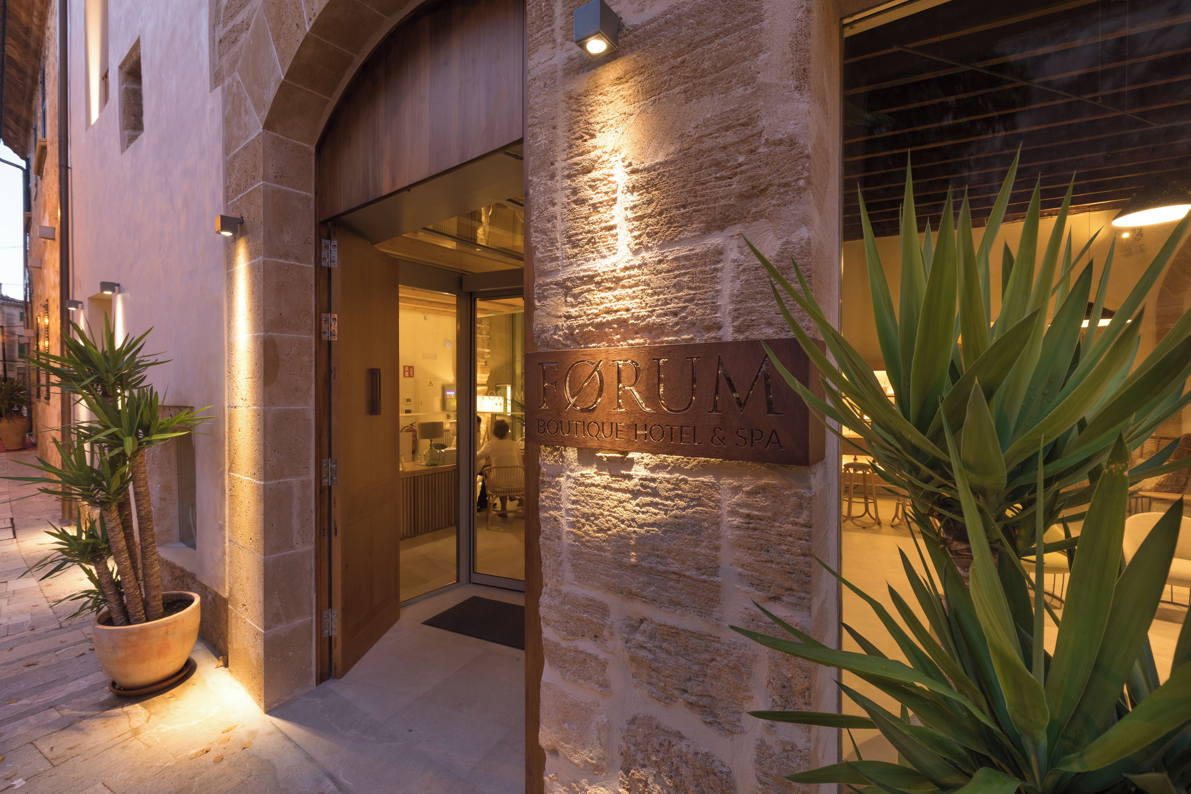Entrada de un edificio de piedra con un letrero que dice 'FORTIM BOUTIQUE HOTEL & SPA'.