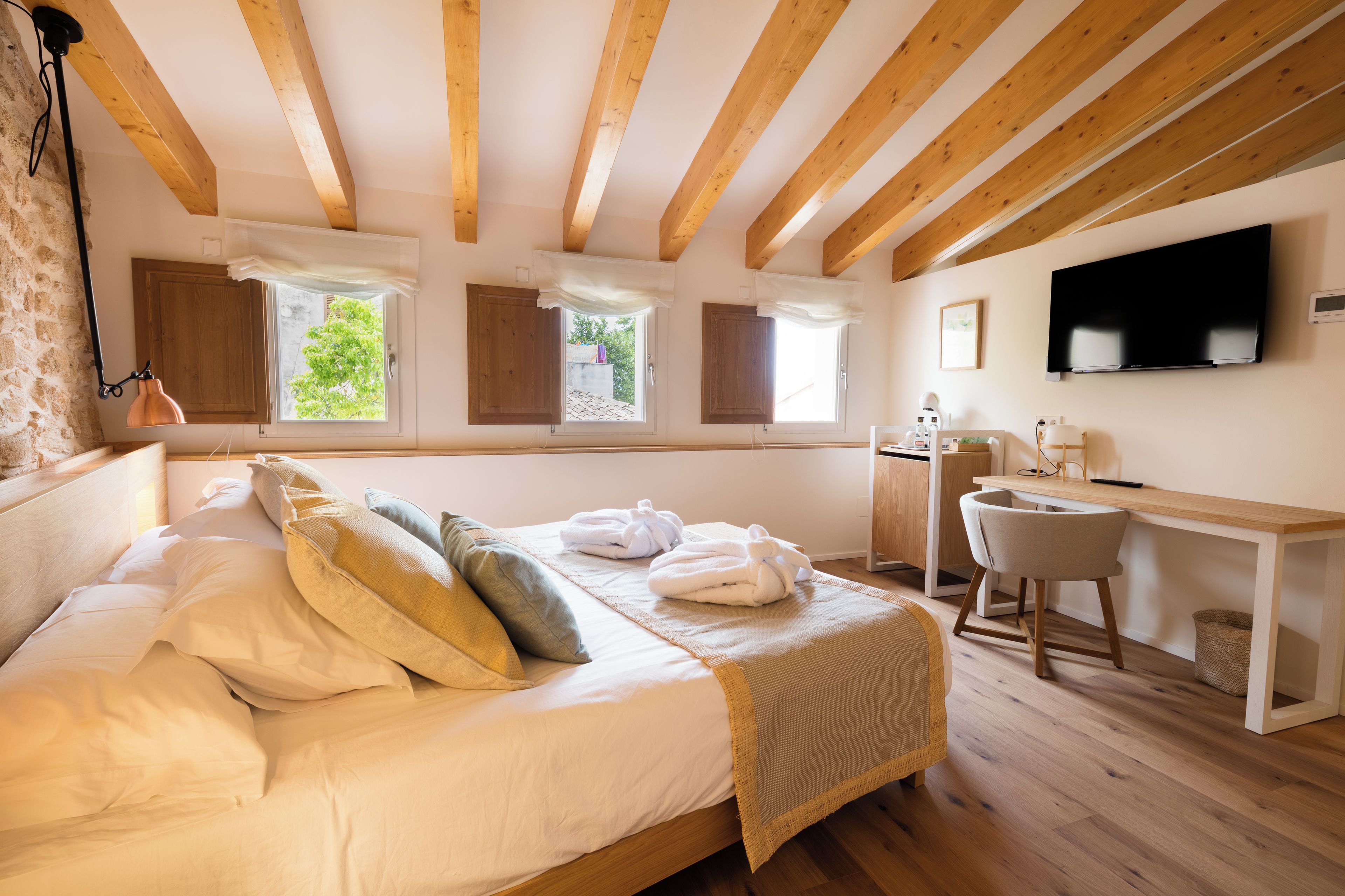 Un dormitorio con cama, escritorio, silla y televisión.