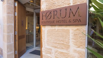 Señal para un hotel boutique y spa con fachada de piedra.