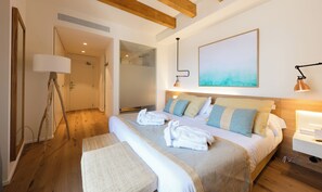 A modern hotel room with a large bed, a bedside table, a lamp, and a painting on the wall. - Forum Boutique Hotel & Spa (Alcúdia)