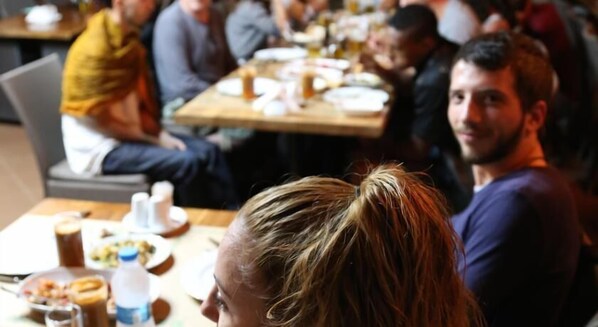 A group of people seated at a table with various dishes and drinks.