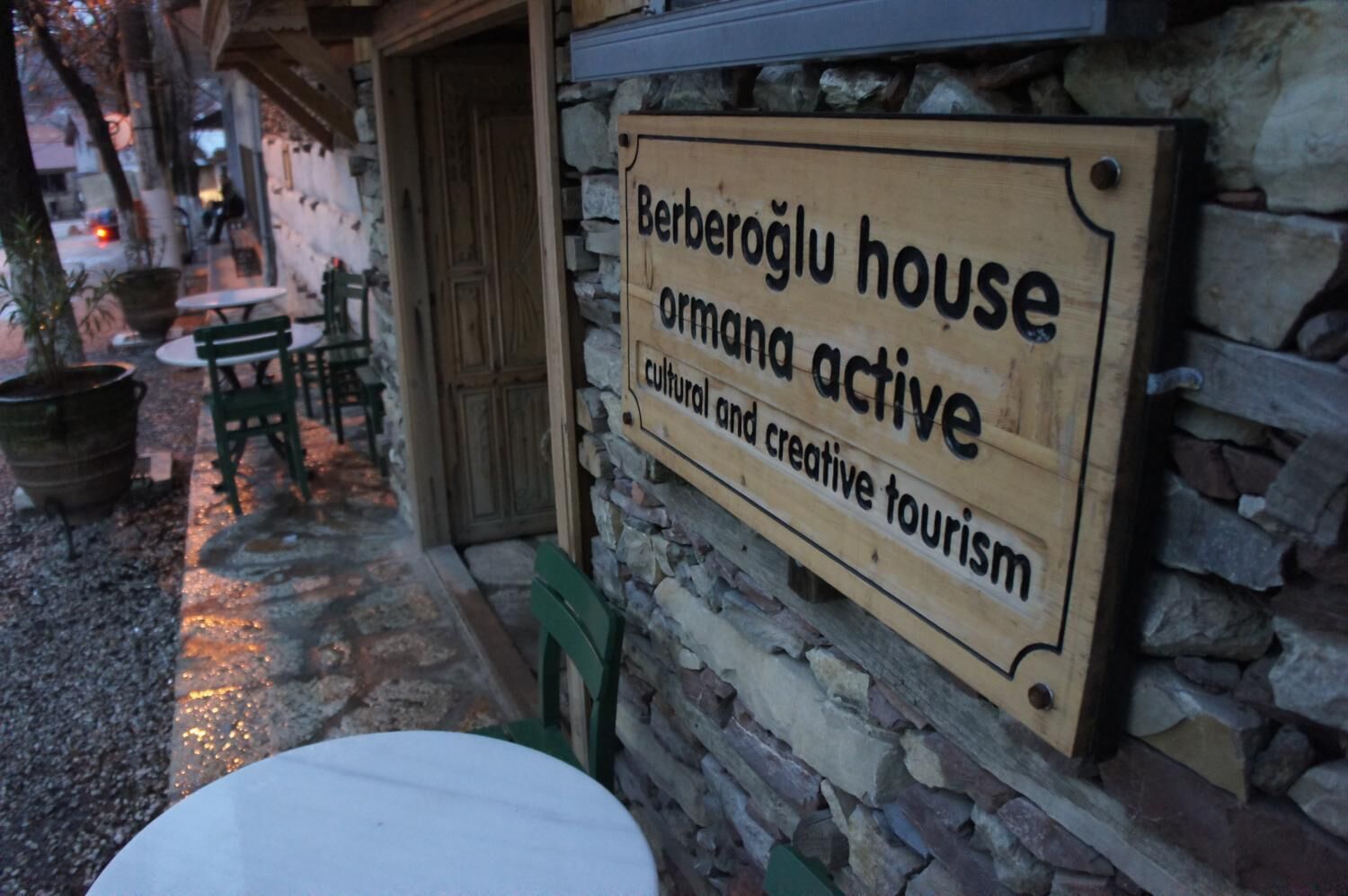 Een houten bordje voor Berberoğlu House, dat aangeeft dat het een actief centrum is voor cultuur en creatief toerisme.