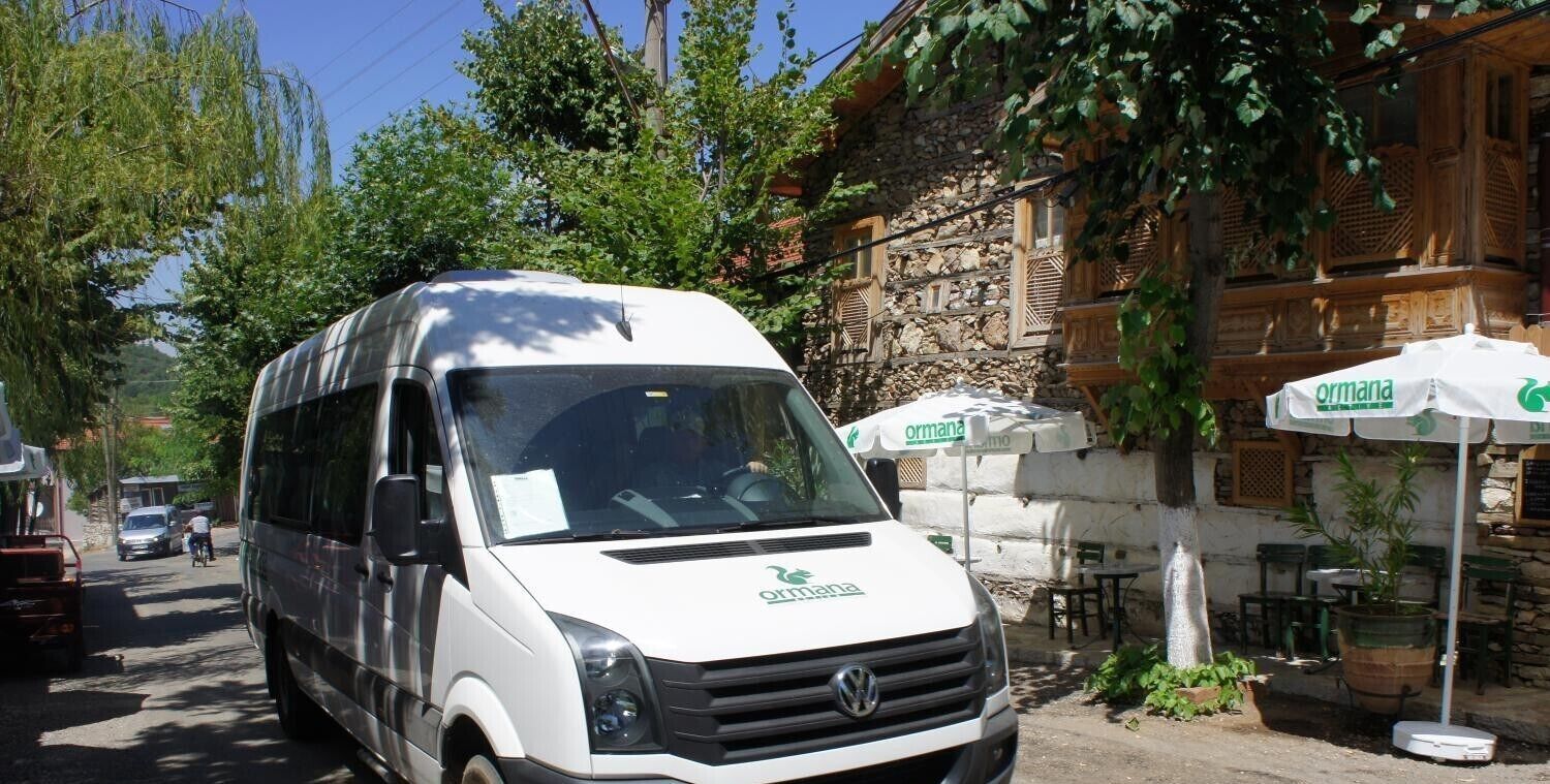 Una camioneta blanca con la marca 'ormana' estacionada en una calle.