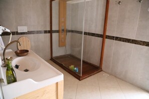 A bathroom with a wooden vanity, a sink, a mirror, and a shower enclosure. - Ormana Active Dogan Boutique Hotel (Ibradi)