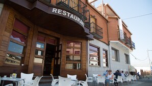 A restaurant with outdoor seating and a wooden facade. - Hostal Acuario (Galvez)