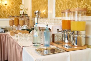 A buffet setup with various food and drink dispensers, a tray, and a table covered with a white tablecloth. - Hotel zur Post (Bernkastel-Kues)