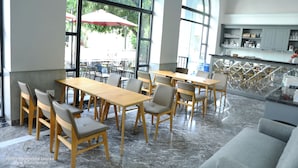 A hotel dining area with wooden tables and chairs, large windows, and a view of the outdoor seating area. - Fide Hotel (Ho Chi Minh City)