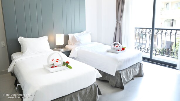 A hotel room with two beds, a large window with a view of the outside, and a balcony. - Fide Hotel (Ho Chi Minh City)