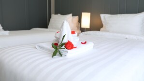 A neatly made bed with a towel and a rose on it, a lamp, and a dark-colored headboard. - Fide Hotel (Ho Chi Minh City)