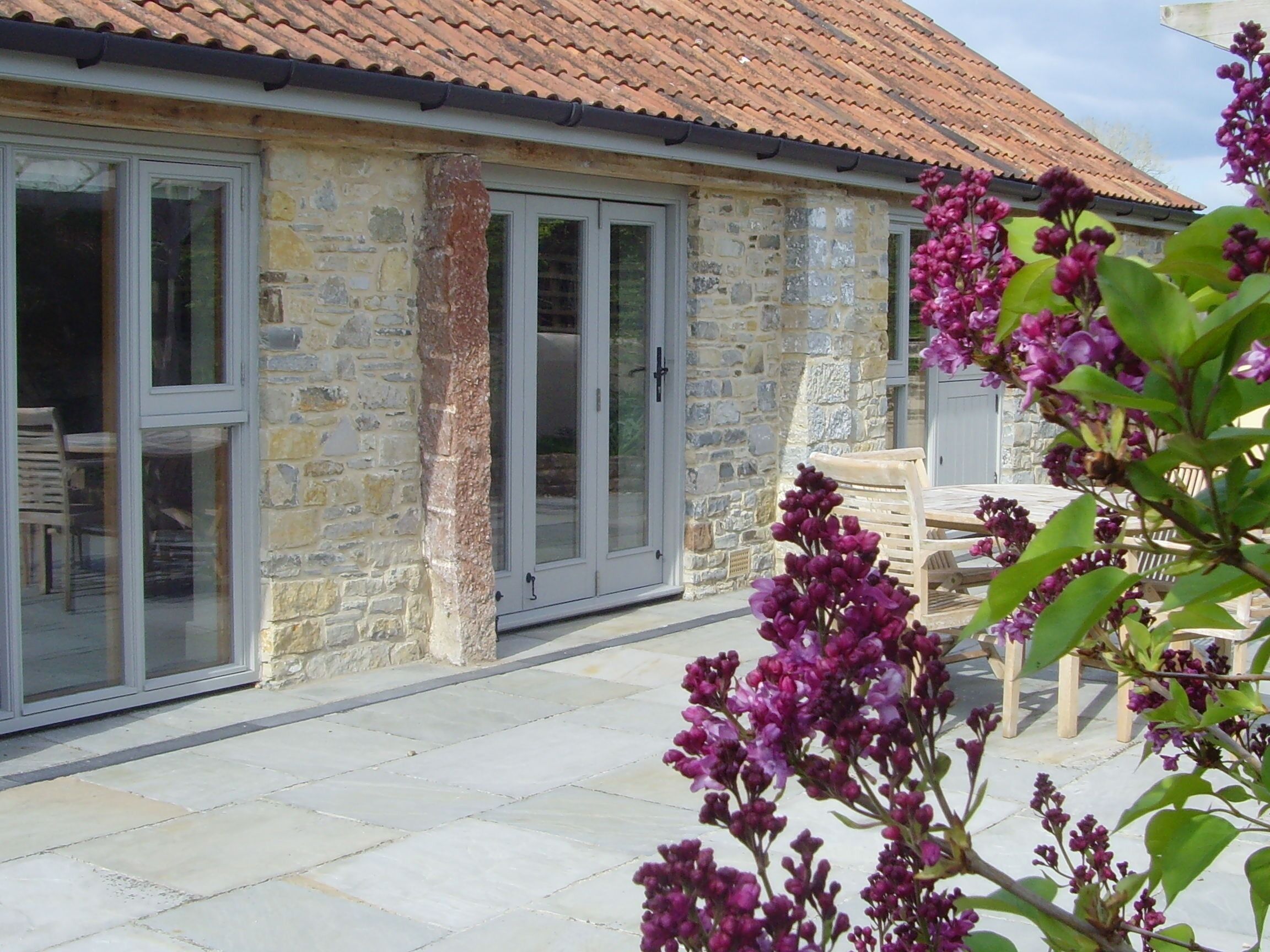 A stone building with large glass doors and a tiled roof.