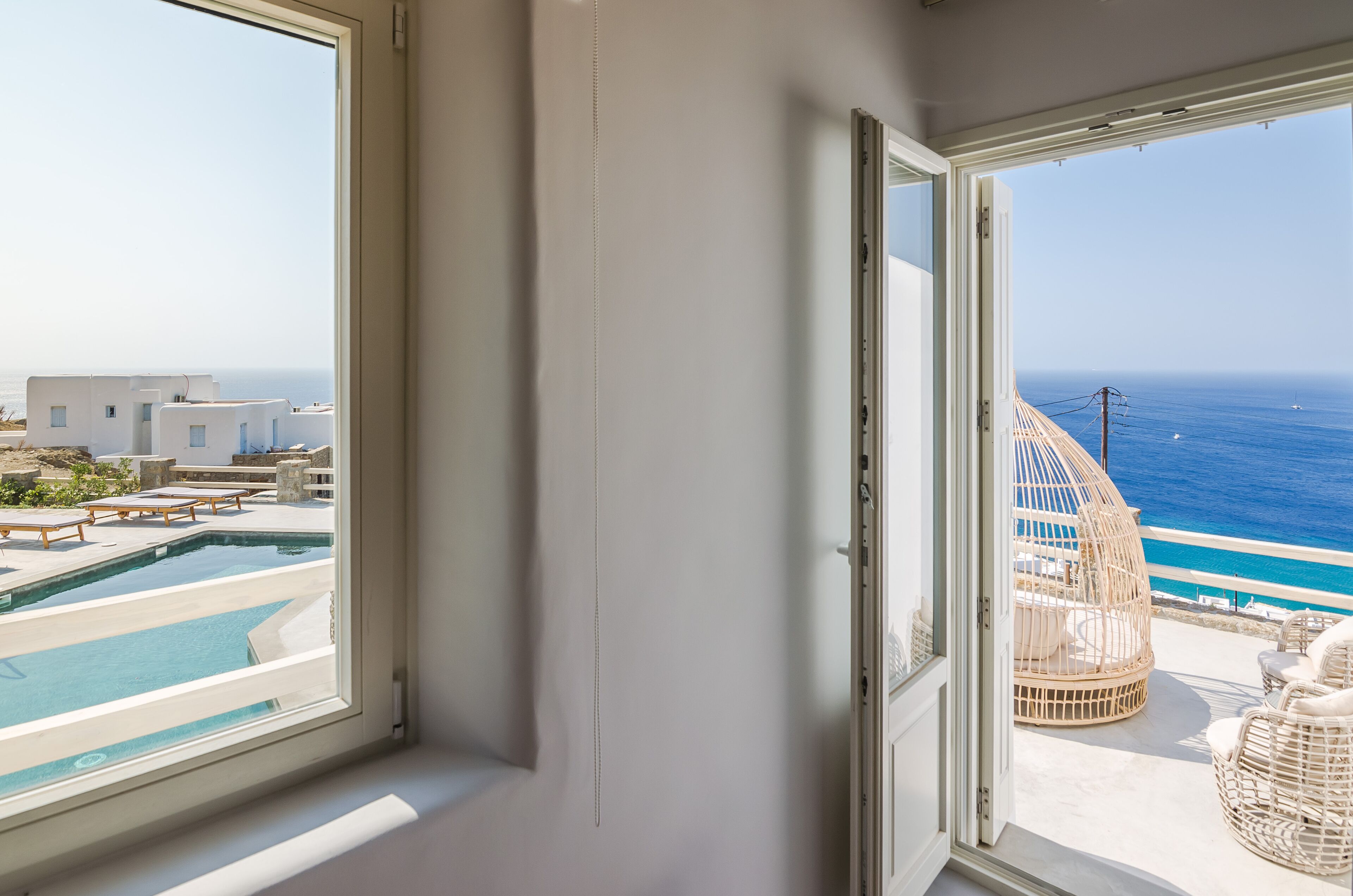 Uma varanda com vista para o mar e uma piscina.