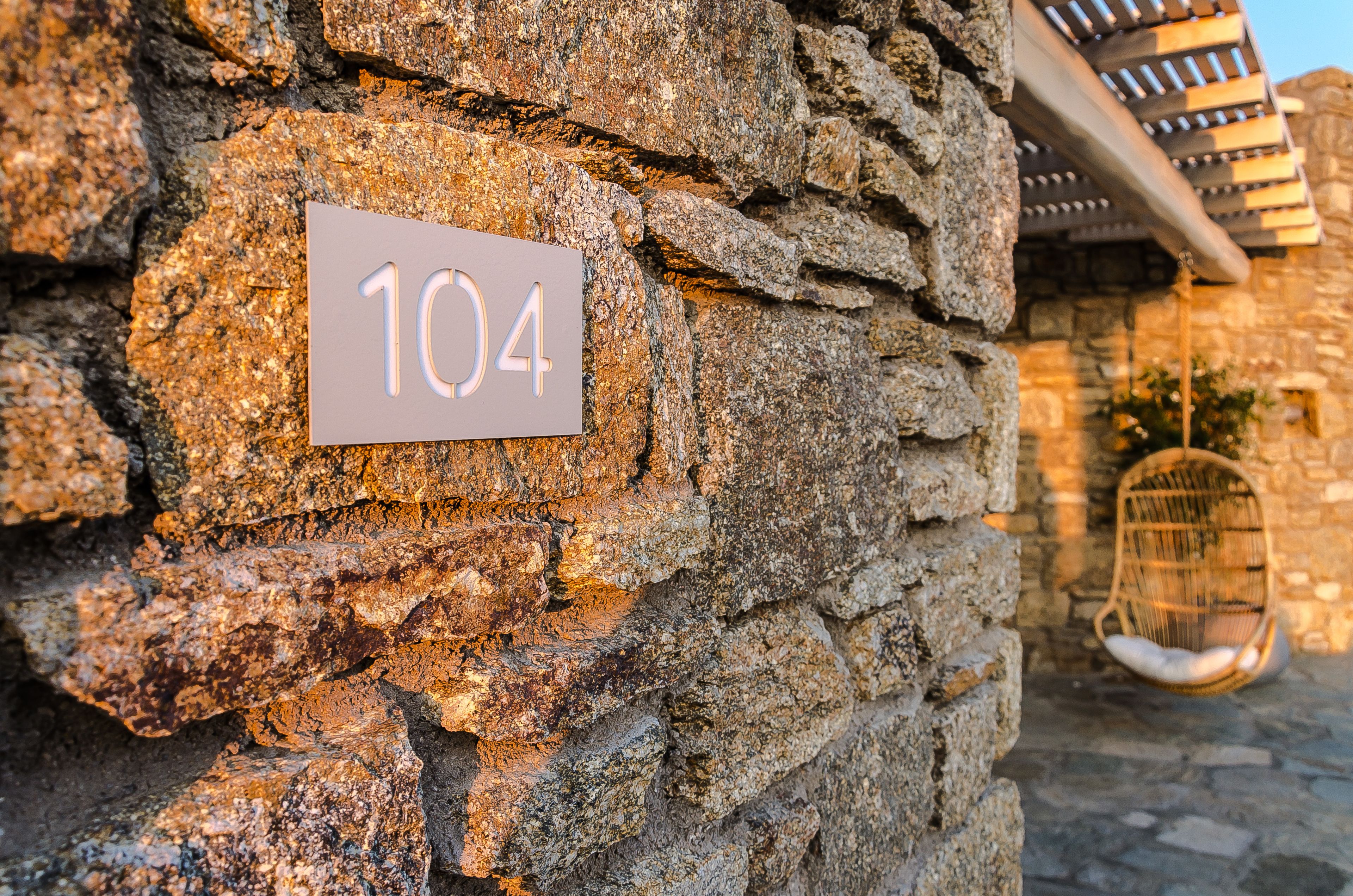 Un muro in pietra con un cartello che riporta il numero 104.