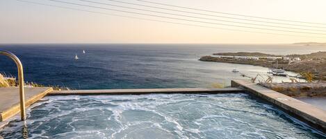A pool with a view of the sea and boats.