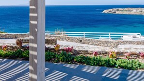 A covered outdoor area with a view of the ocean and rocky coastline. - Eden View Suites & Villas (Mykonos)
