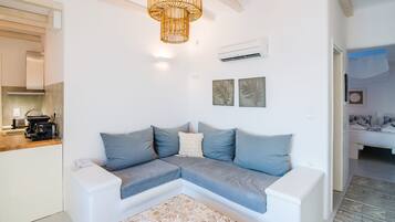Una sala de estar moderna con un sofá modular, una mesita y una lámpara colgante.