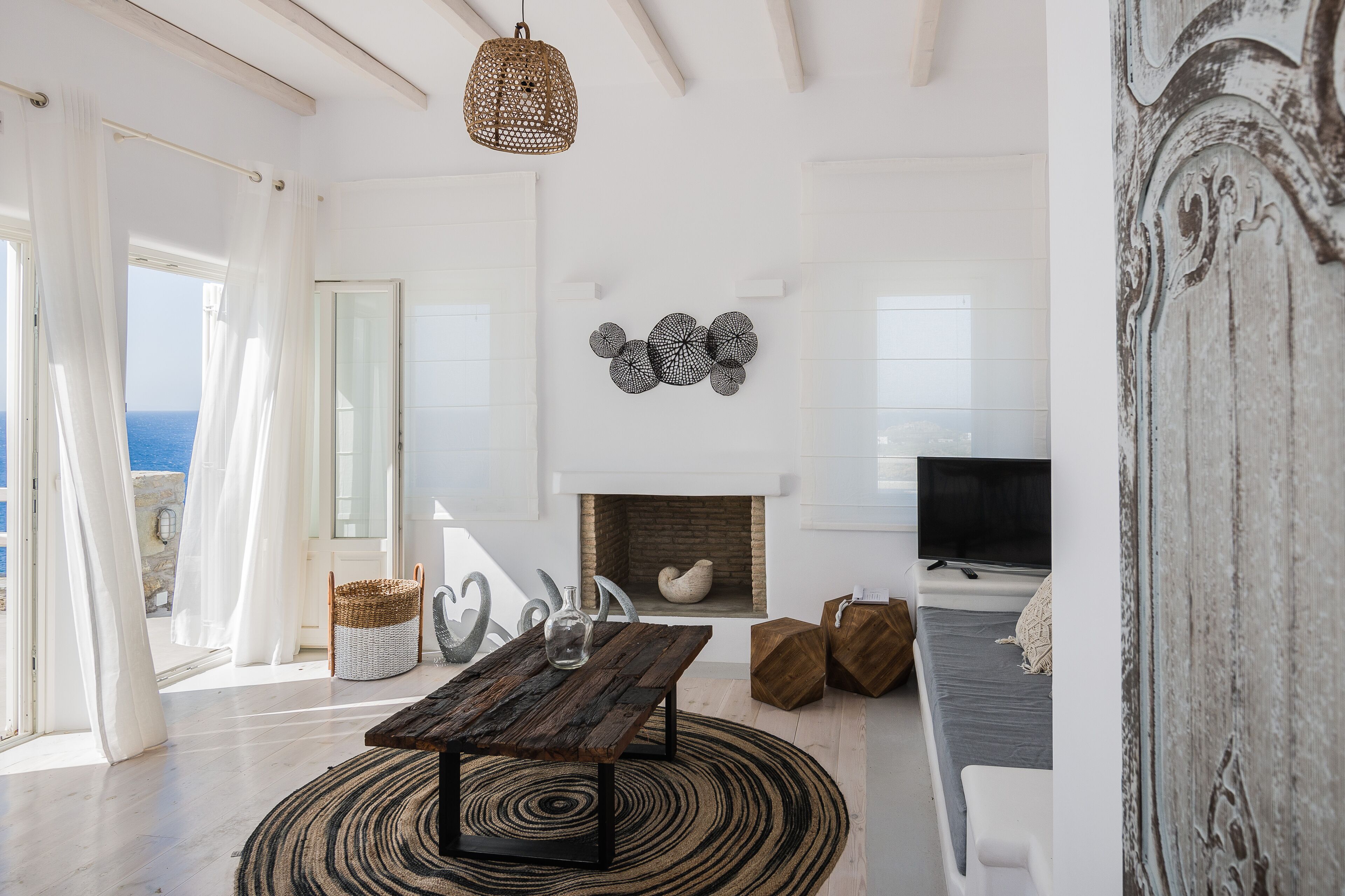 Un salon spacieux avec une cheminée, un téléviseur et une vue sur la mer.