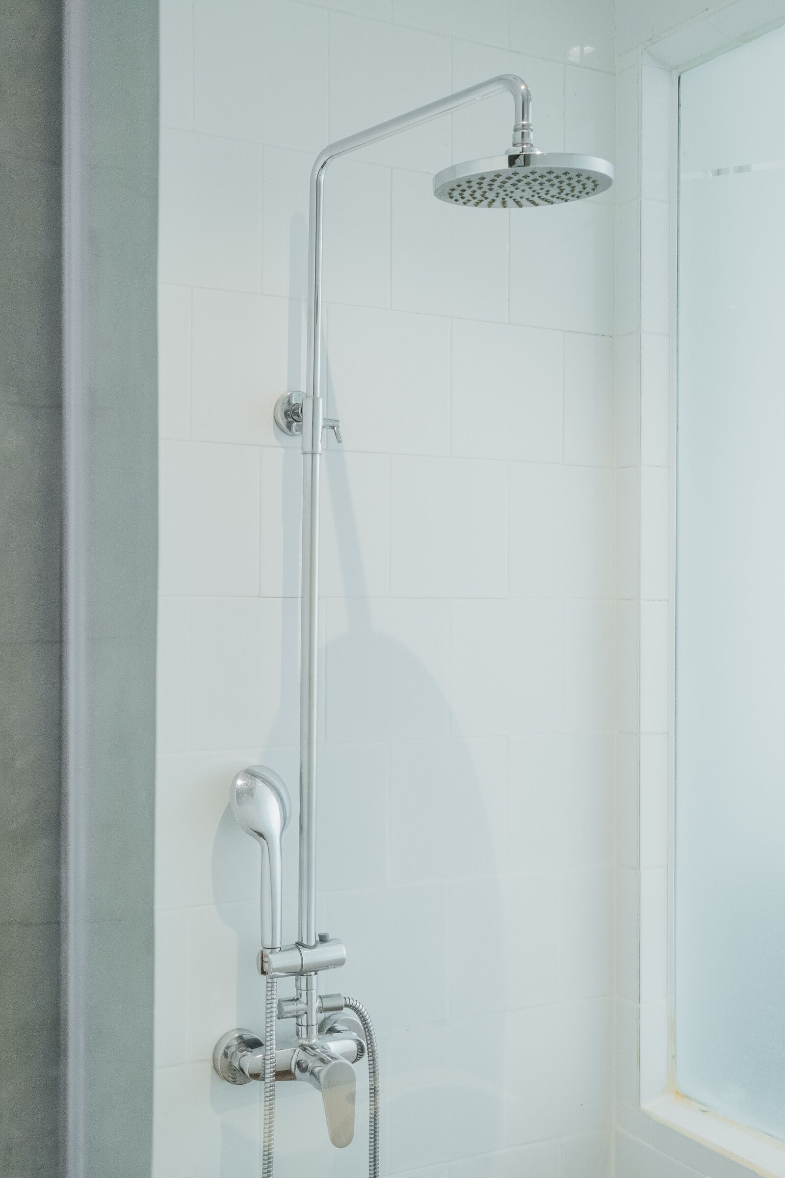 Eine Dusche mit Handbrause und Armaturen an der Wand.