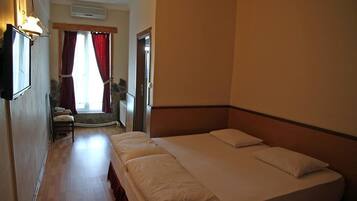 Una habitación de hotel con una cama grande, un escritorio, una silla y una ventana con cortinas.