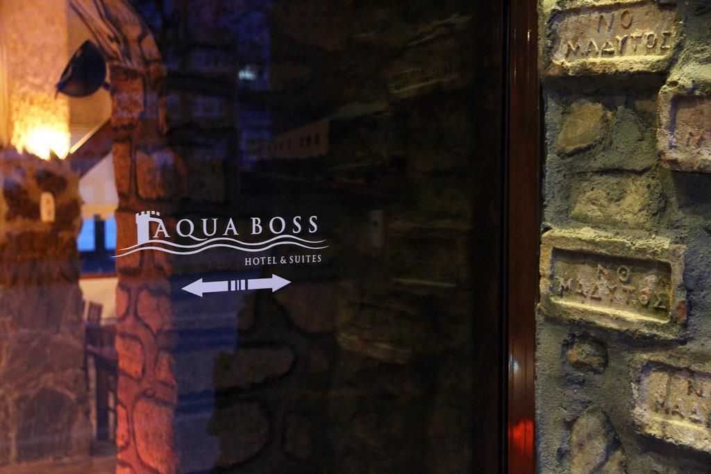 Señalización para el hotel Aqua Boss Hotel & Suites, con flechas indicando dirección.