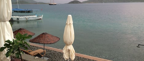 Pantai pribadi, kursi berjemur, dan payung pantai