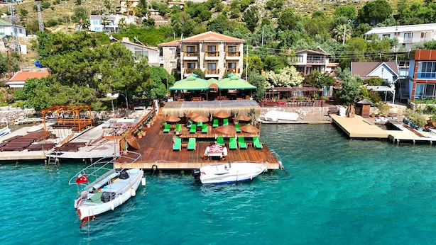 A waterfront restaurant with outdoor seating, a pool, and boats. - Veranda Otel Bozburun (+16) (Marmaris)