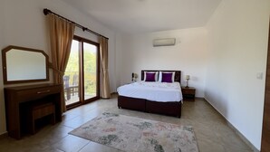 A bedroom with a bed, a desk, a chair, a window with curtains, and an air conditioning unit. - Veranda Otel Bozburun (+16) (Marmaris)