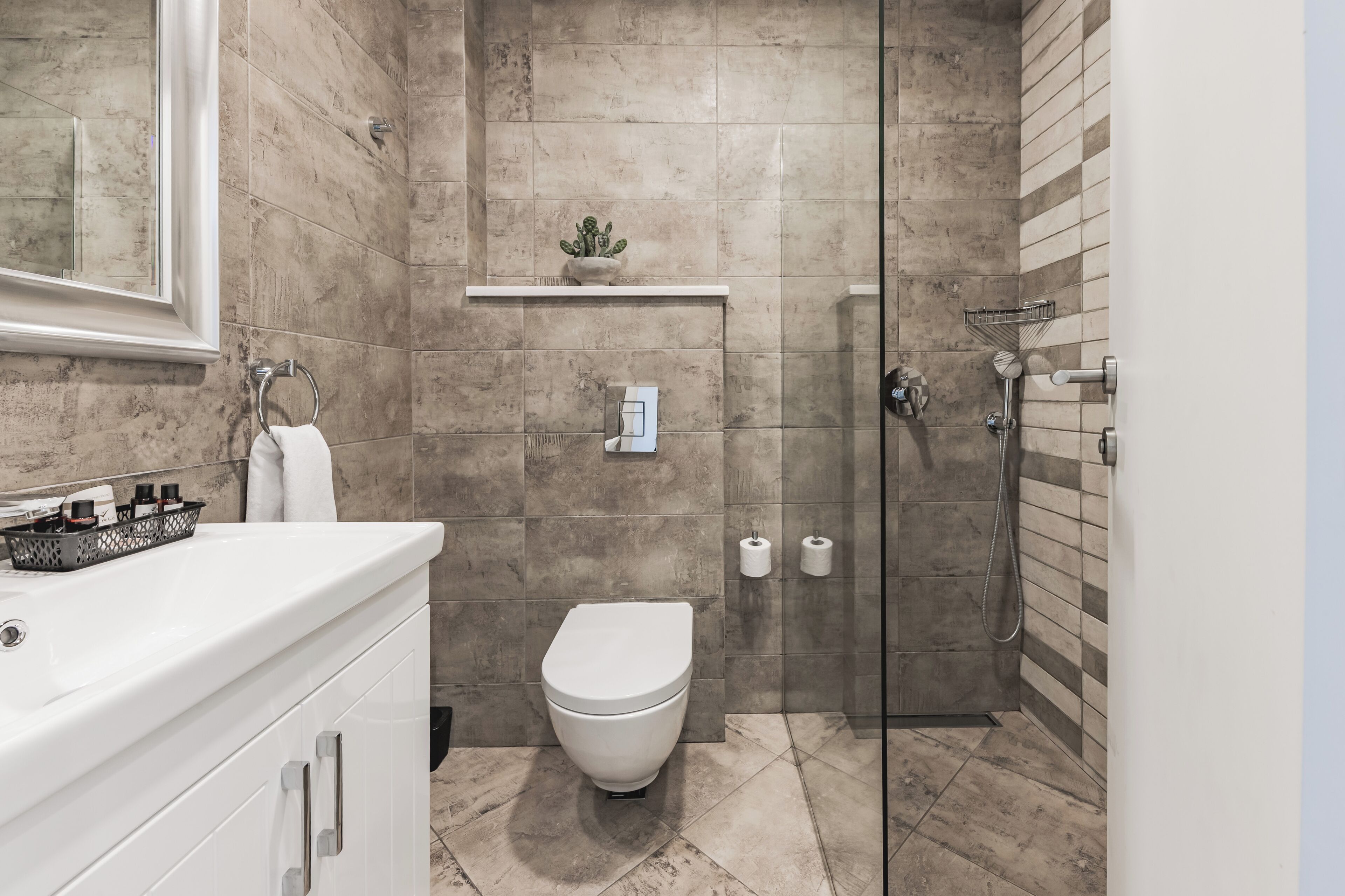A modern bathroom with a shower, toilet, and sink.
