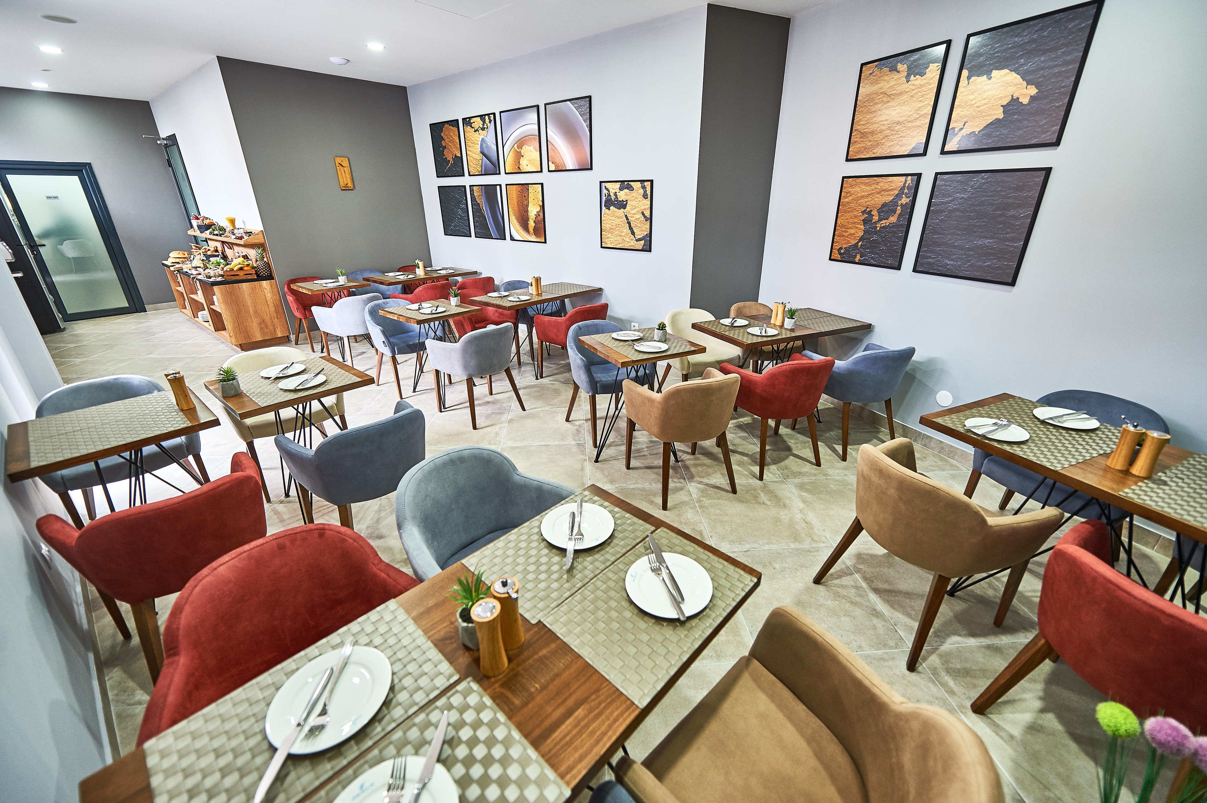 A dining area with multiple tables and chairs, some with plates and cutlery.