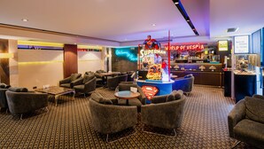 Un vestíbulo con zonas de estar, una exhibición temática de Superman y una zona de bar.