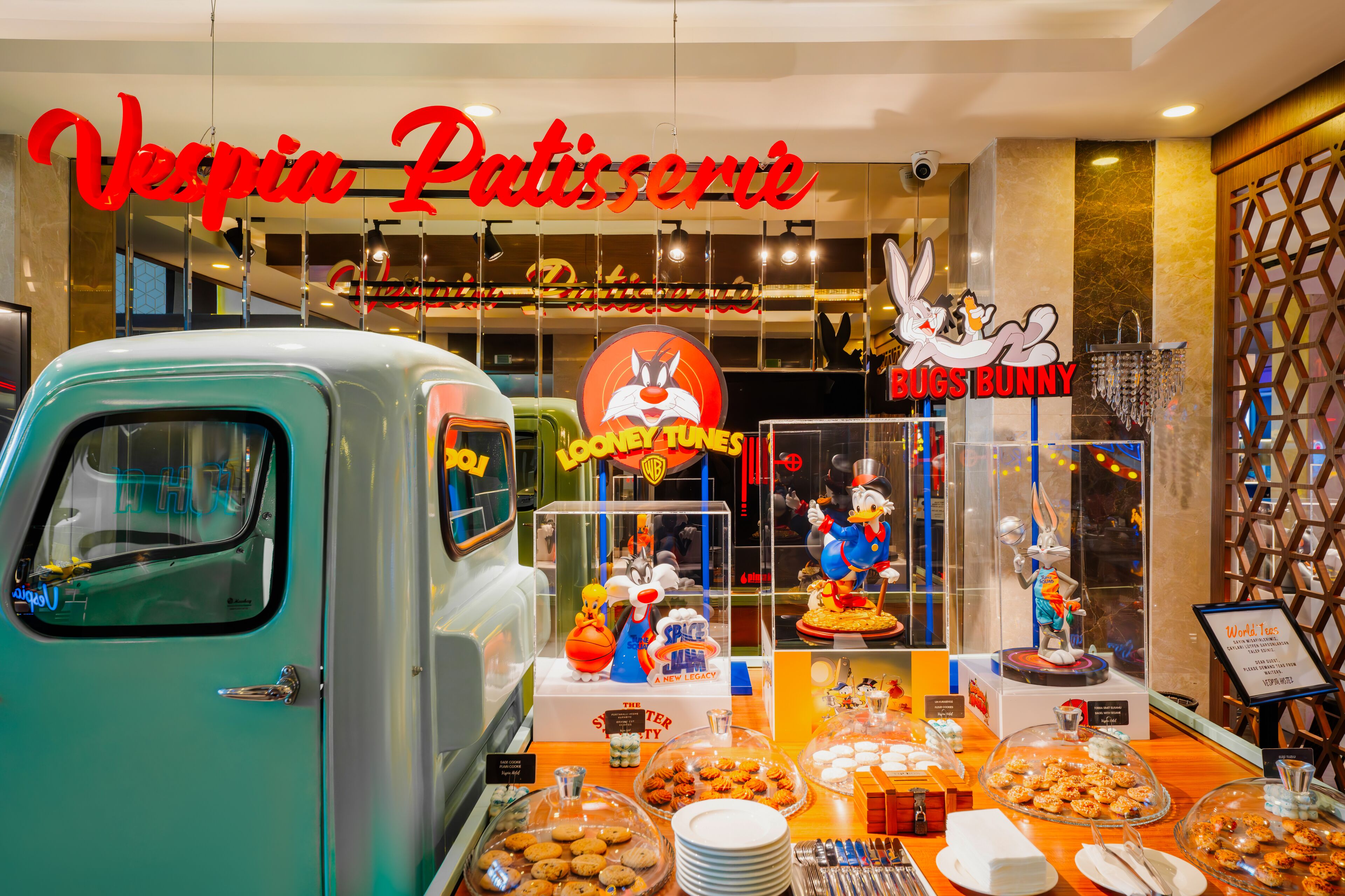 Un restaurante de estilo vintage con un letrero de neón, una estatua de Bugs Bunny y varios mostradores de comida.