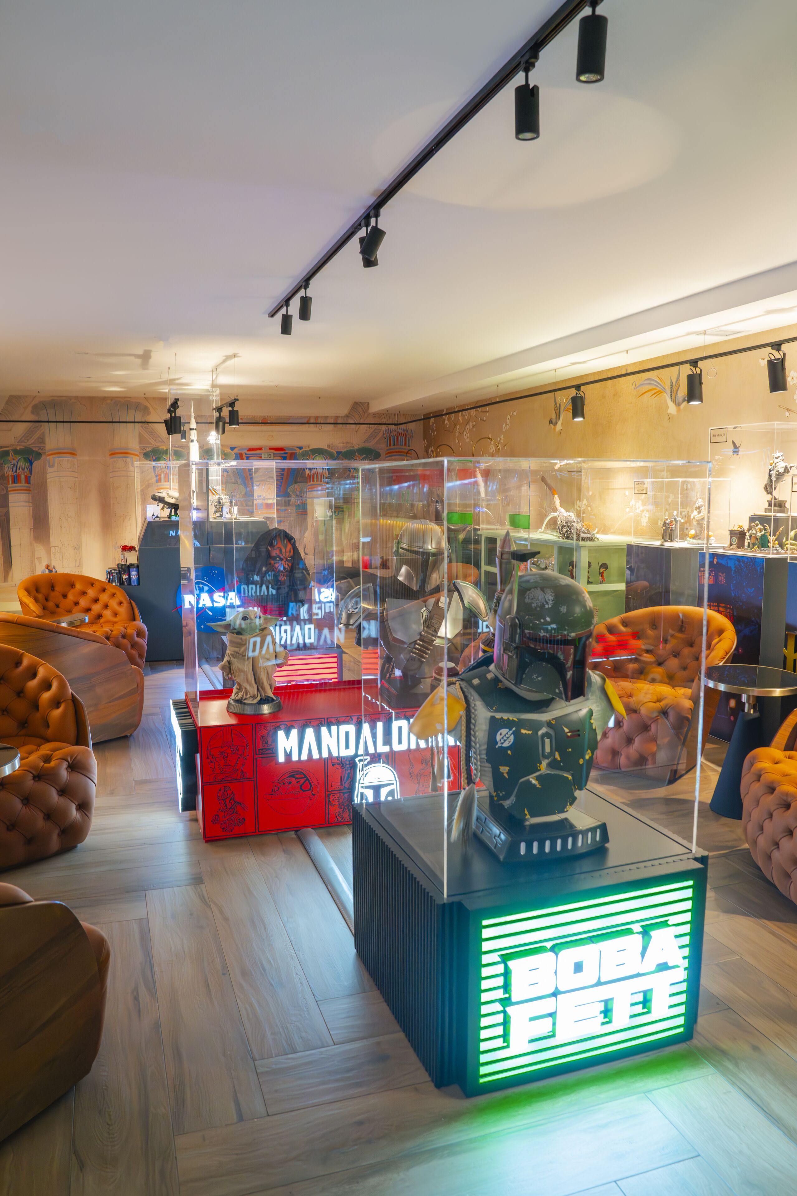 A room with a modern design, featuring a large window, a plush sofa, and a display case with collectibles.