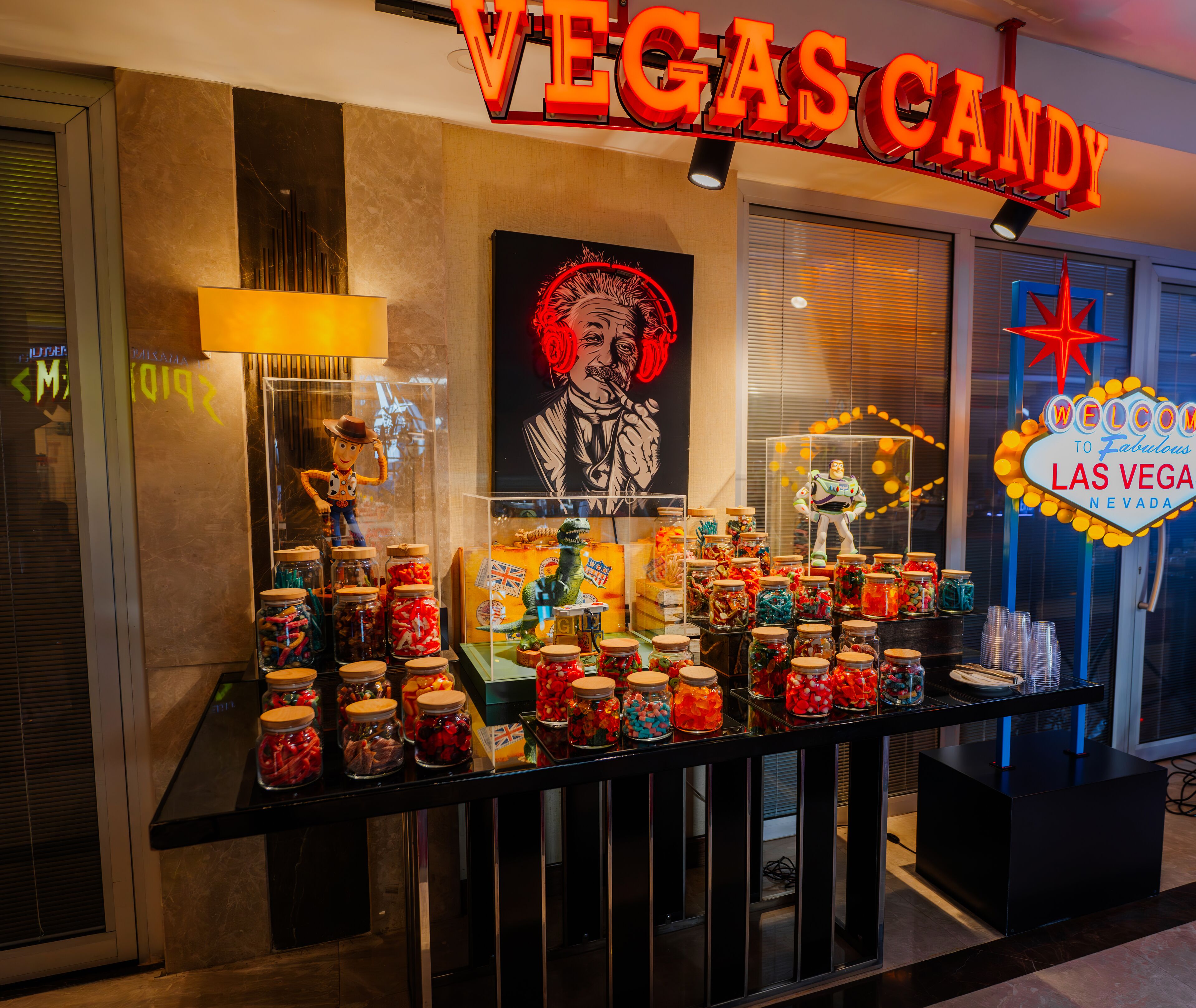 Un présentoir de bonbons dans une confiserie de Las Vegas, avec des bocaux remplis de bonbons et une figurine de Toy Story.