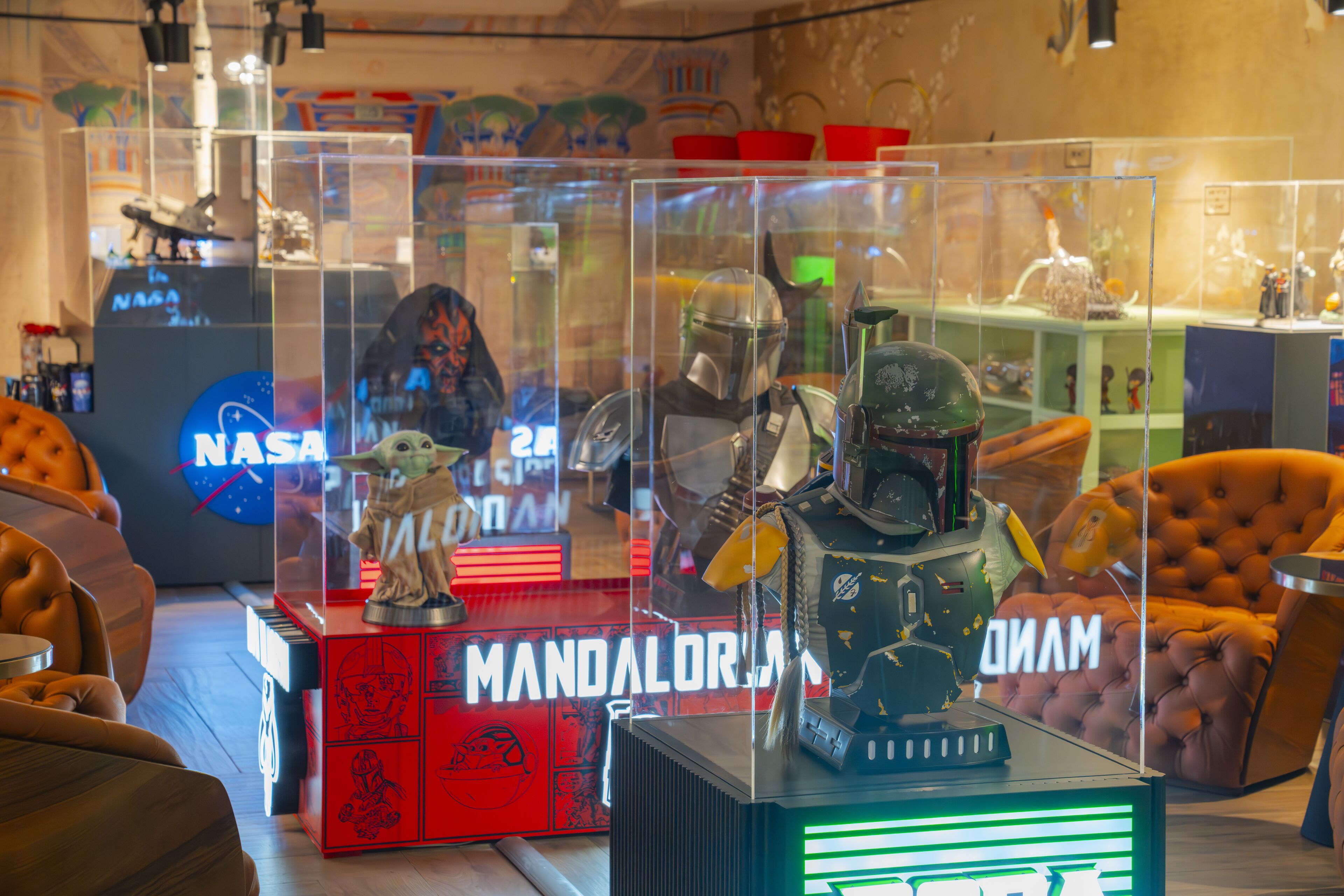 A display of collectibles including a 'Mandalorian' themed item, a 'NASA' sign, and a 'Star Wars' helmet.