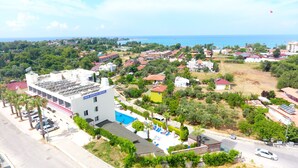 A hotel with a swimming pool, surrounded by greenery and residential buildings. - Side Kervan Hotel (Manavgat)