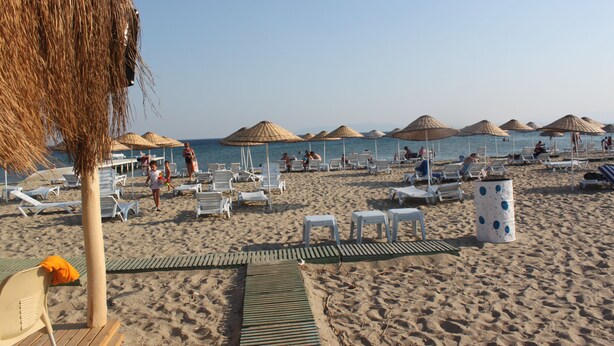 A beach with sun loungers, umbrellas, and a wooden walkway. - Side Kervan Hotel (Manavgat)