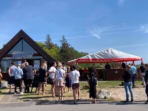 A group of people standing outside a building with a sign that reads "Vandkanten." - Birkelygaard Bed & Breakfast (Millinge)