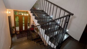 Eine moderne Treppe mit schwarzen Geländern und einer Glastür, die auf einen Balkon führt.