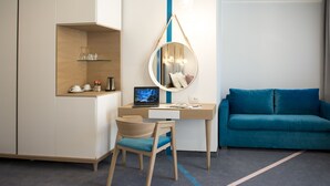 Une chambre moderne équipée d’un bureau, d’une chaise et d’un canapé bleu.