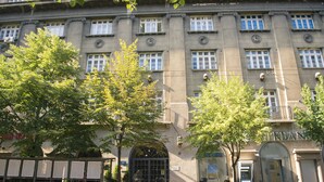 A building with a large arched entrance, a sign reading "BANK", and two motorcycles parked in front. - City Nest Modern & Cozy Suites (Belgrade)
