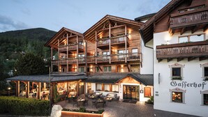 A multi-story wooden building with balconies, a cafe area with outdoor seating, and a sign reading "Saferhof". - Hotel Gasserhof Tradition & Lifestyle (Bressanone)