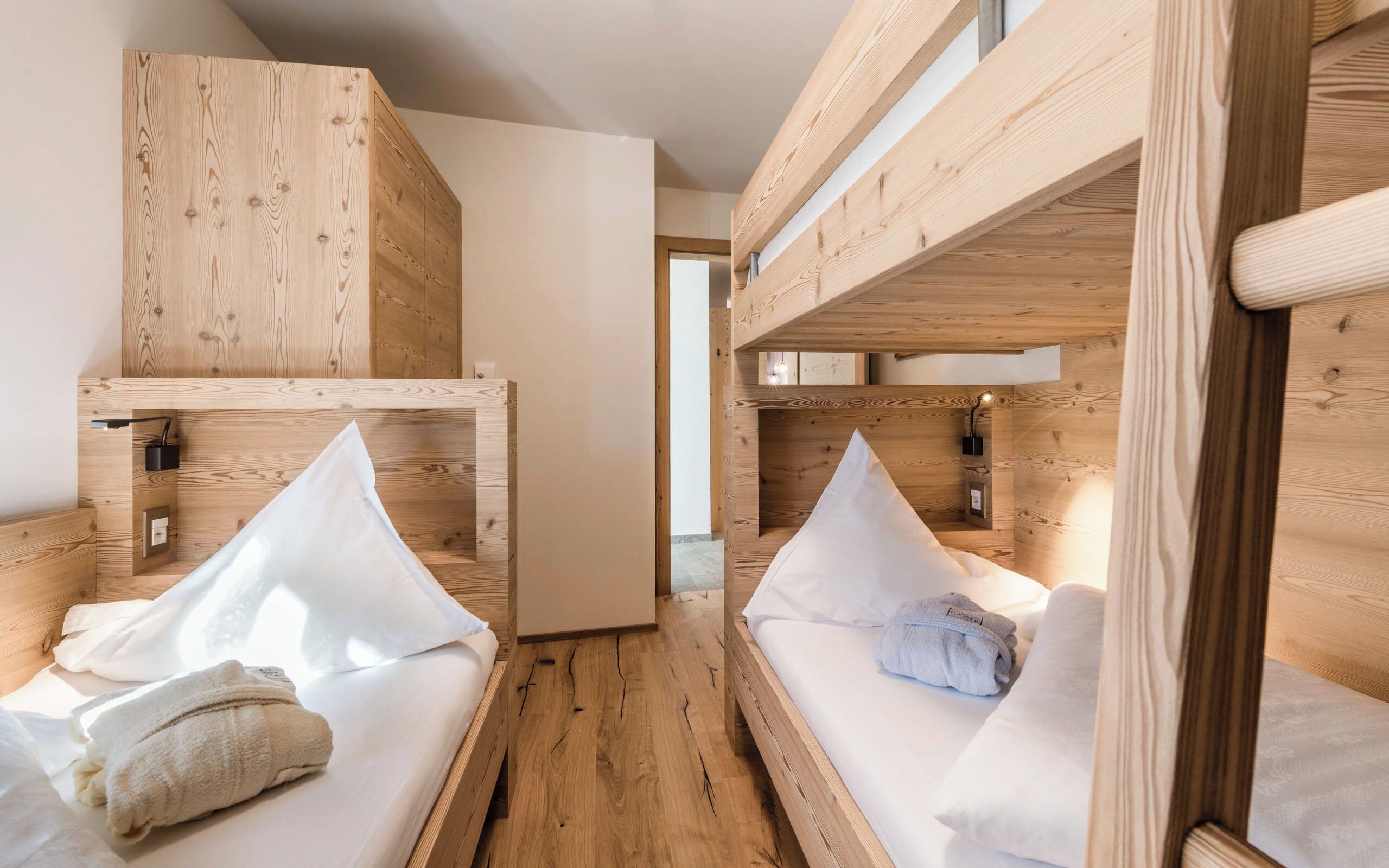 Um quarto com beliches, paredes de madeira e um design simples e funcional.
