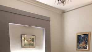 Een moderne slaapkamer met een groot bed, een nachtkastje, een wandlamp en een ingelijste foto boven het bed.