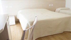 Een hotelkamer met een bed, een bureau en een stoel.