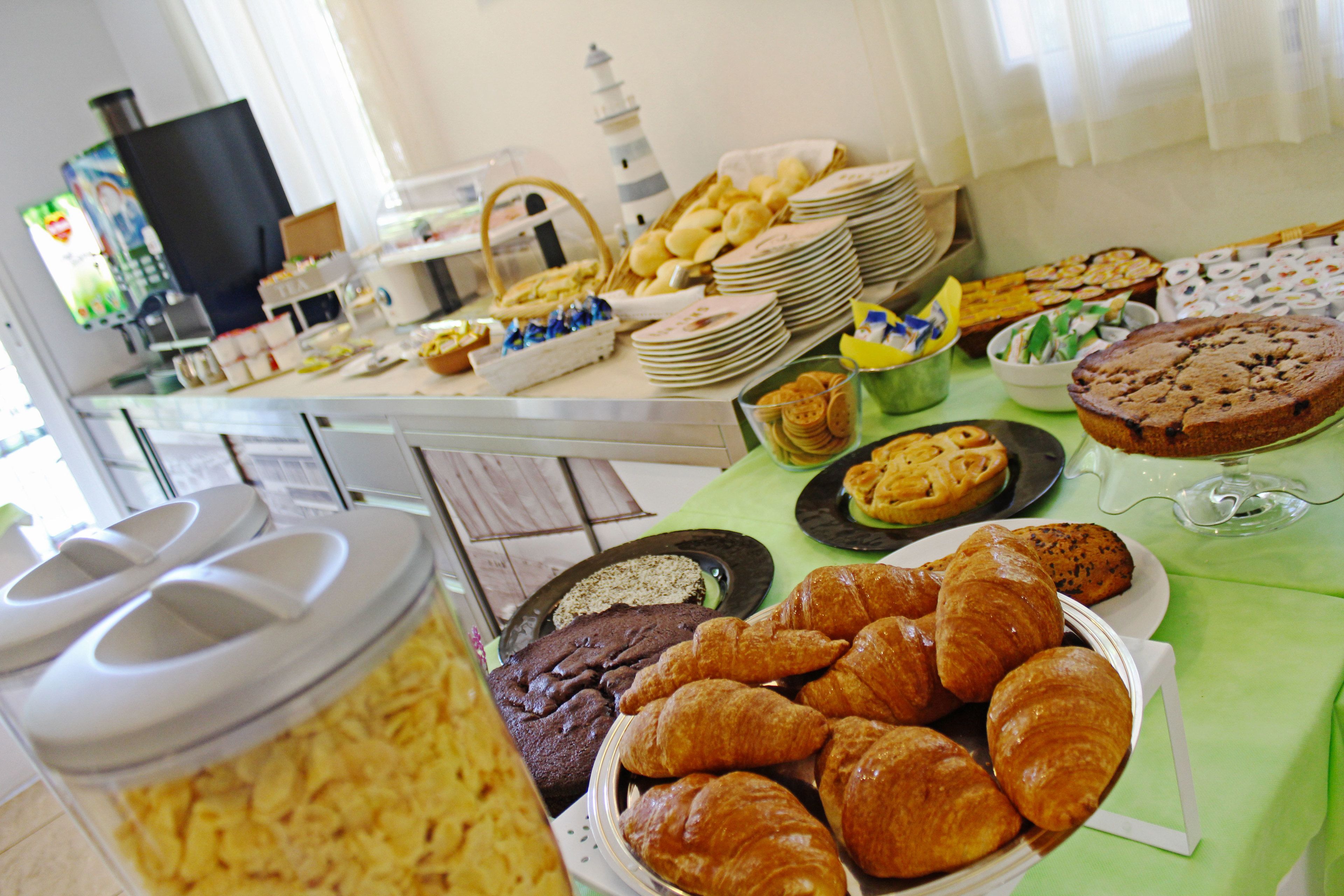 A buffet table with various baked goods and pastries.