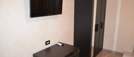 A small room with a desk, chair, and a wardrobe.