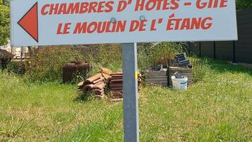 A directional sign with text in French, pointing towards 'Chambres d'Hôtes - Gîte le Moulin de l'Étang'.