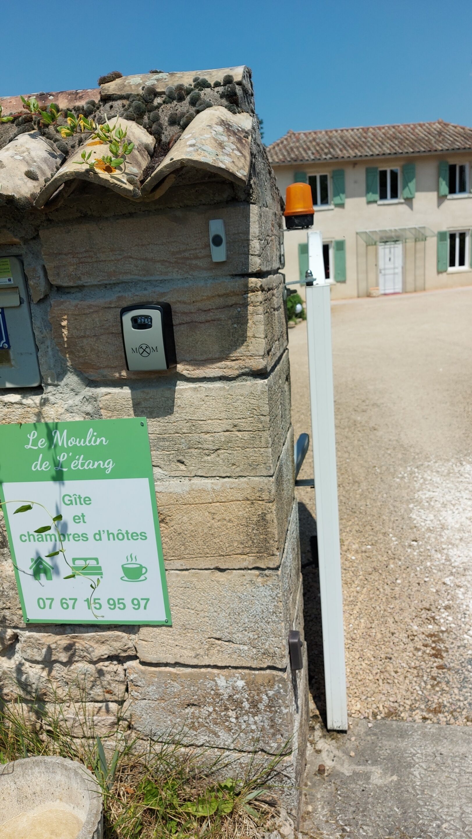 Un bâtiment en pierre sur lequel est apposée une enseigne indiquant qu’il s’agit d’une maison d’hôtes avec des chambres et un café.