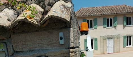 A stone building with a sign indicating it is a guesthouse with rooms and a café.