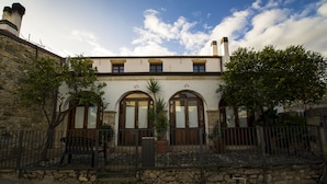 A building with a stone facade, arched windows, and a tiled roof. - Locanda La Rosa (Pauli Arbarei)